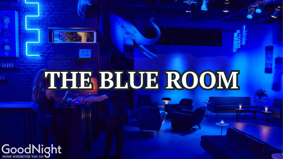 A stylish, dimly-lit cocktail bar with plush sofa seating, neon signage, and unique decor. The bar area beckons for evening drinks and intimate conversation, capturing the mystery and allure of Nashville’s nightlife.