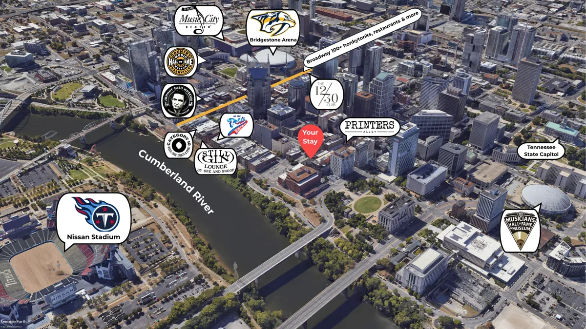 This sweeping cityscape view captures the Cumberland River, Bridgestone Arena, Nissan Stadium, and the heart of downtown Nashville. The vibrant energy of the city is evident, with inviting venues for dining, concerts, and nightlife all within view.